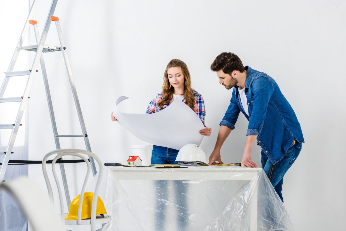 couple looking at blueprint during home repairs